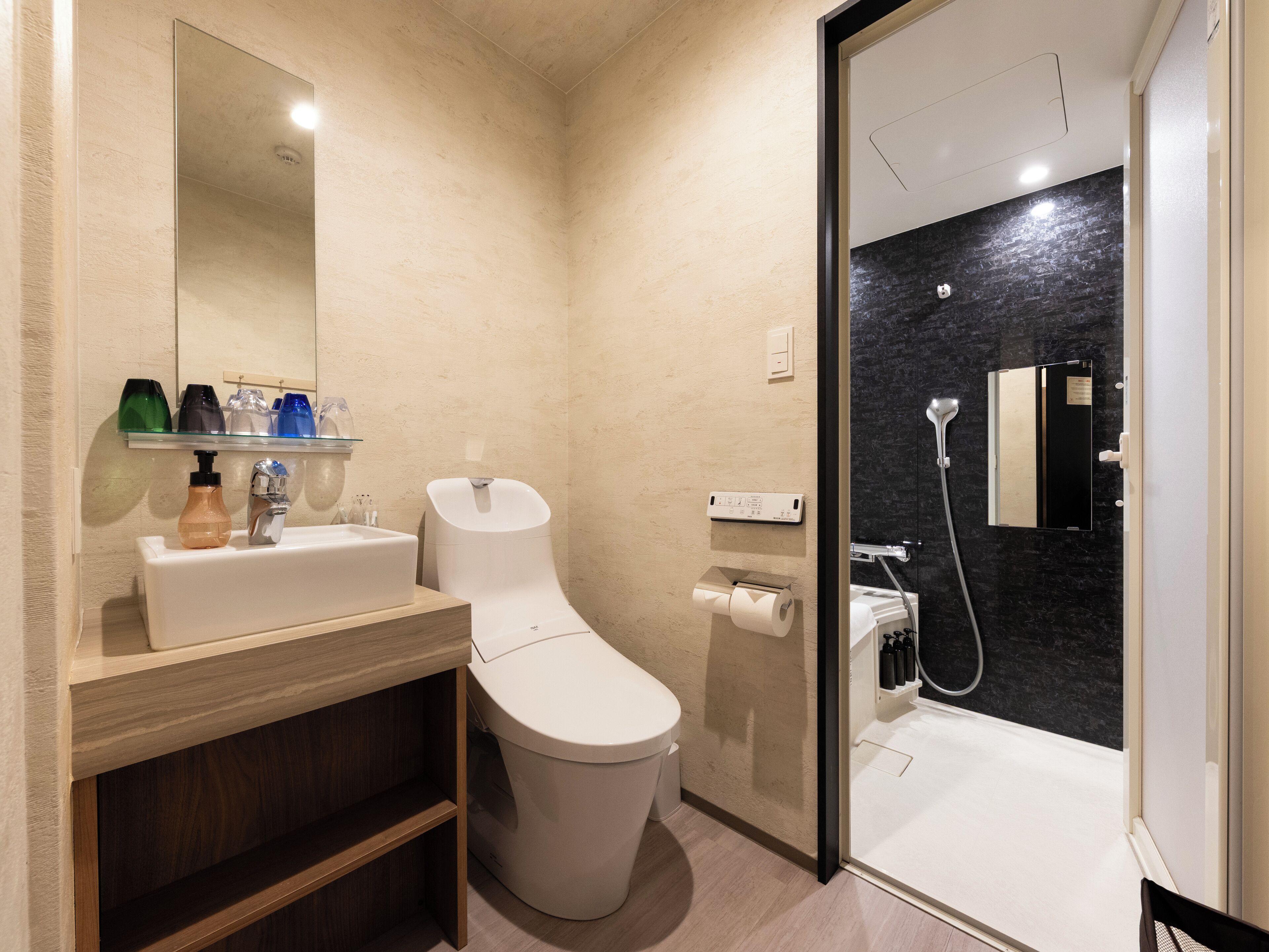 A modern bathroom with a toilet, sink, and shower area.