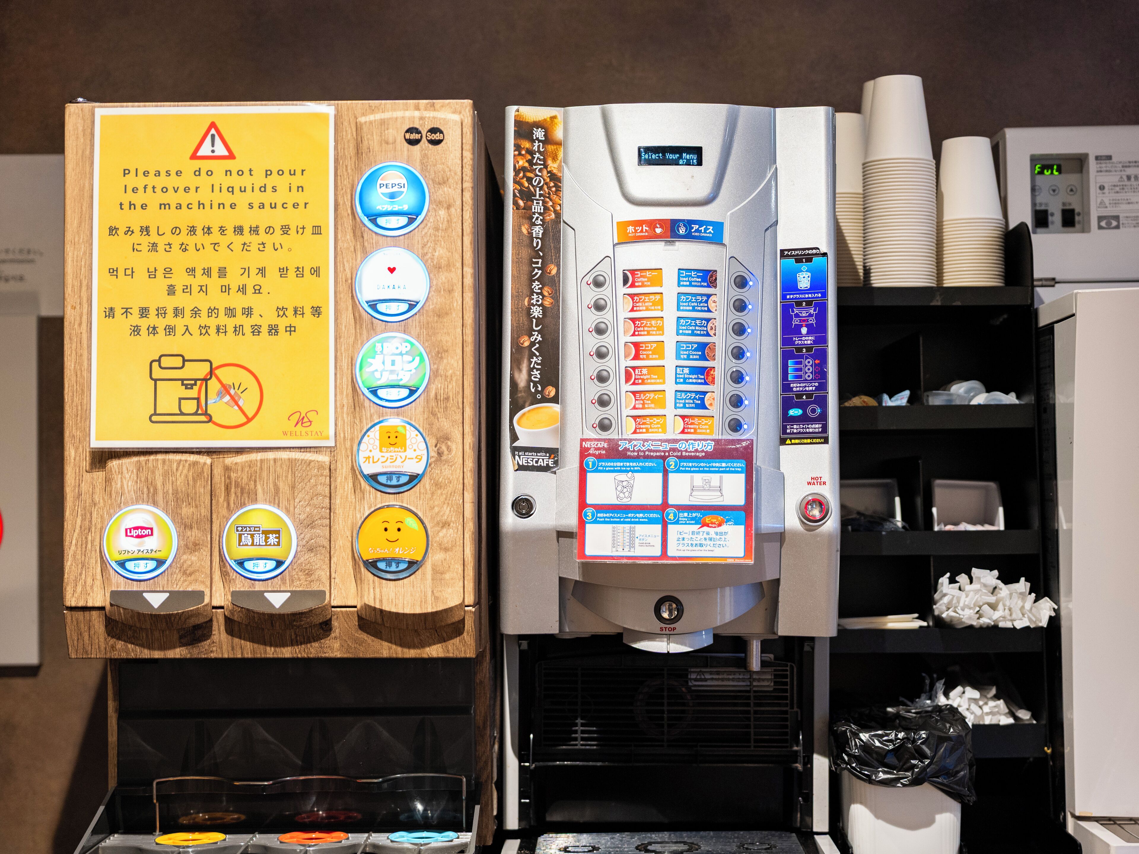 Une machine à café offrant plusieurs options de boissons et munie d’un avertissement indiquant qu’il ne faut pas verser les liquides restants dans la machine.