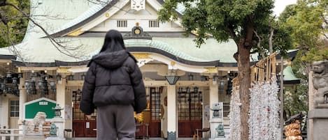 Un edificio tradicional con techo curvo y una estatua en primer plano.