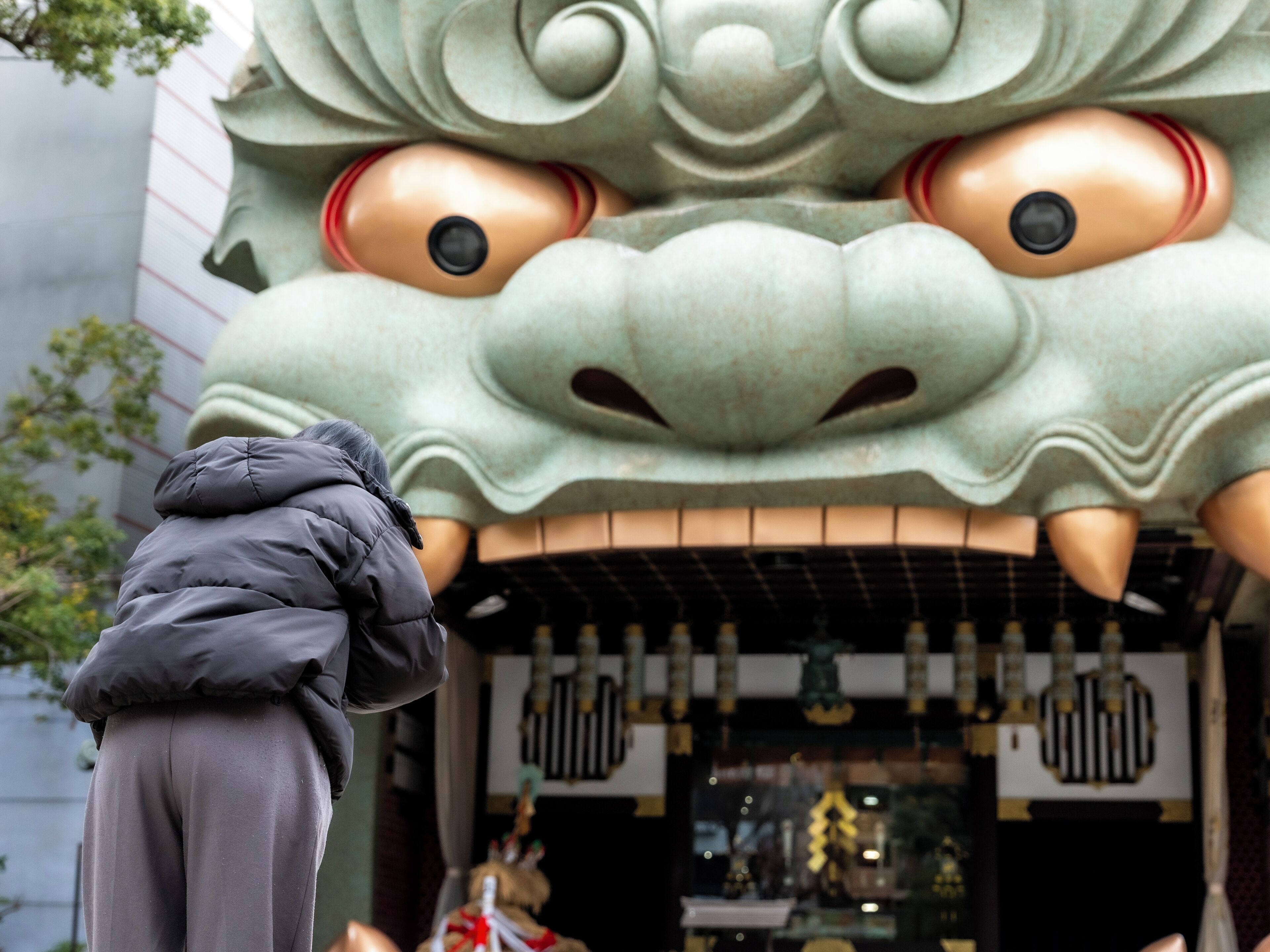 Une personne prend une photo d’une grande statue de lion richement décorée.