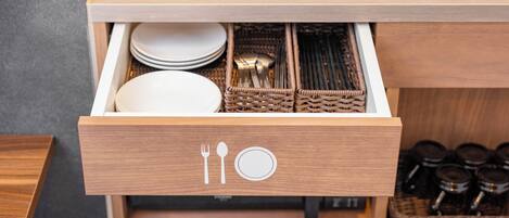 A kitchen drawer with utensils and plates.