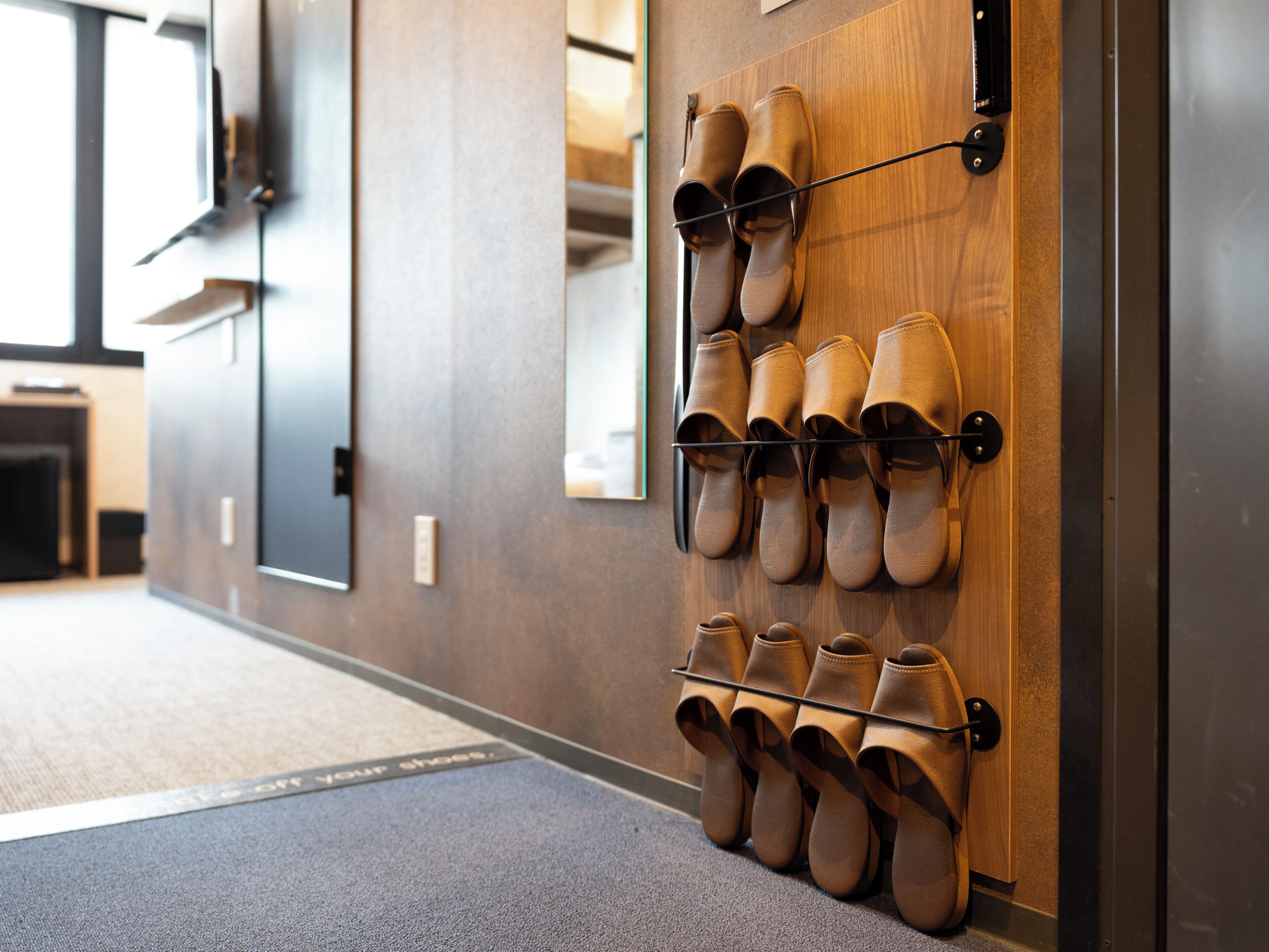 A wall-mounted shoe rack with multiple pairs of shoes.