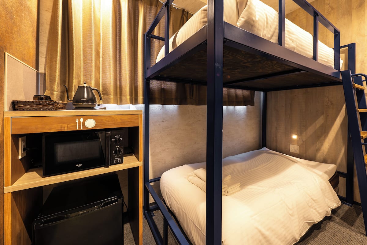 Ein Etagenbett mit Schreibtisch und Mikrowelle.