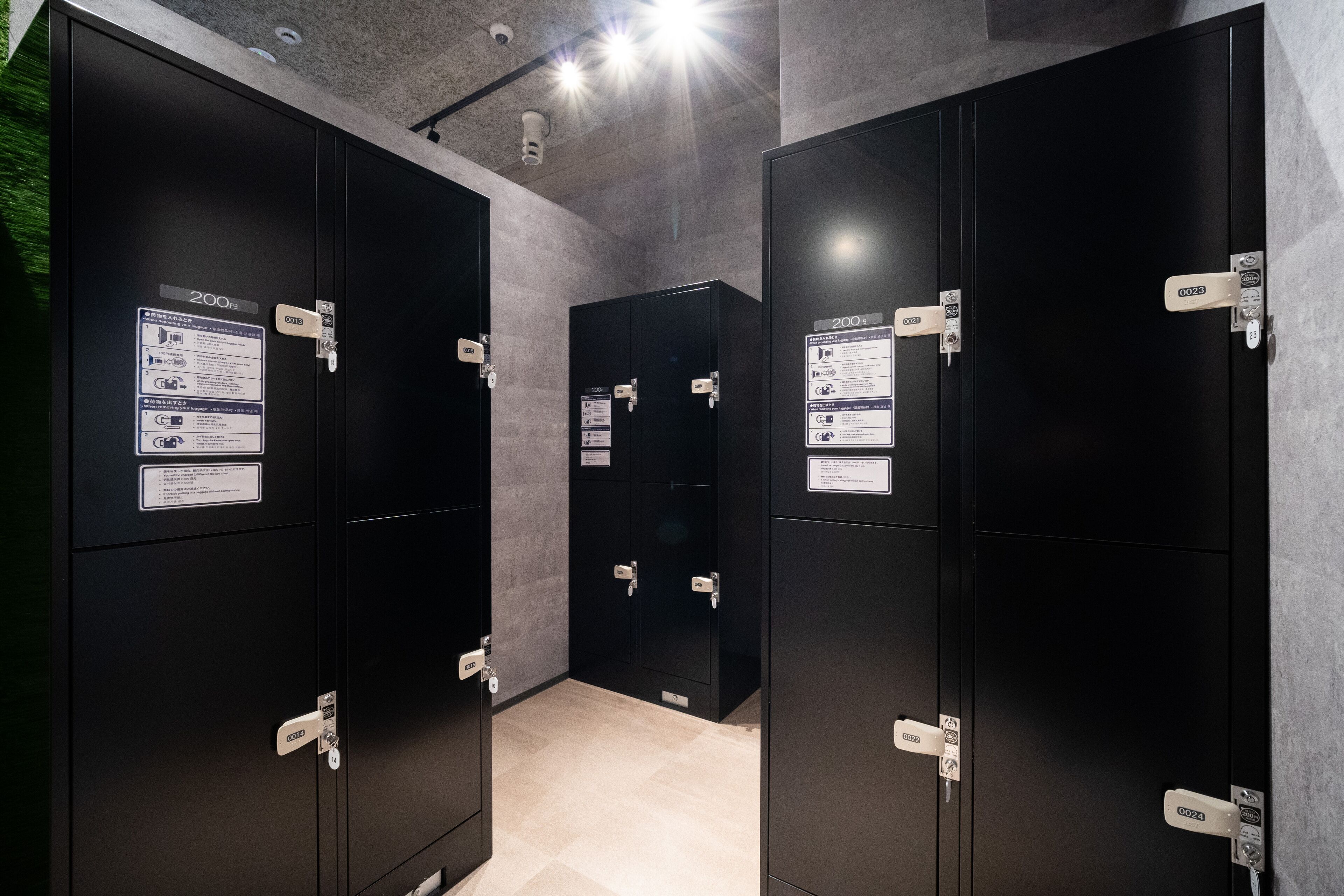 Une rangée de casiers noirs, chacun ayant une capacité de 200 mètres, équipée de serrures électroniques et d’une caméra de surveillance placée au-dessus.