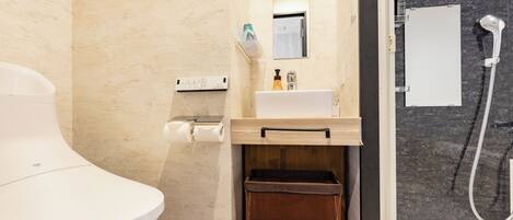 A modern bathroom with a toilet, sink, and shower.