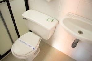 A bathroom with a toilet and a sink. - Hotel Plaza Mayor Itagui (Itagüí)