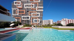 A swimming pool with a modern building in the background. - T2 standing Praia da Rocha (21052 / AL) (Portimão)