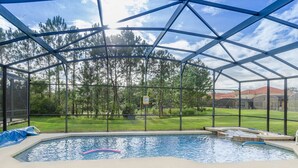 A covered swimming pool with a view of a grassy yard and trees. - Tigerlilly Private Pool Villa (Davenport)