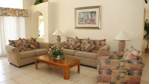 A living room with two sofas, a coffee table, and two lamps. - Ic018or (Kissimmee)