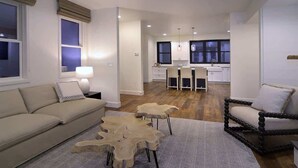 A modern living room with a sofa, a coffee table, a chair, and a dining area with a table and chairs. - Casa Blanca (Crested Butte)