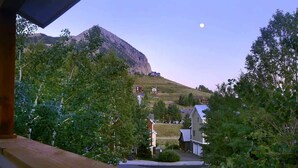 A residential area with houses, a mountain, and a moon in the sky. - Casa Blanca (Crested Butte)