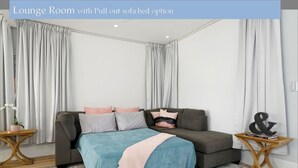 A lounge room with a pull-out sofa bed option. - A Luxurious Beachfront Getaway  (Blacksmiths)
