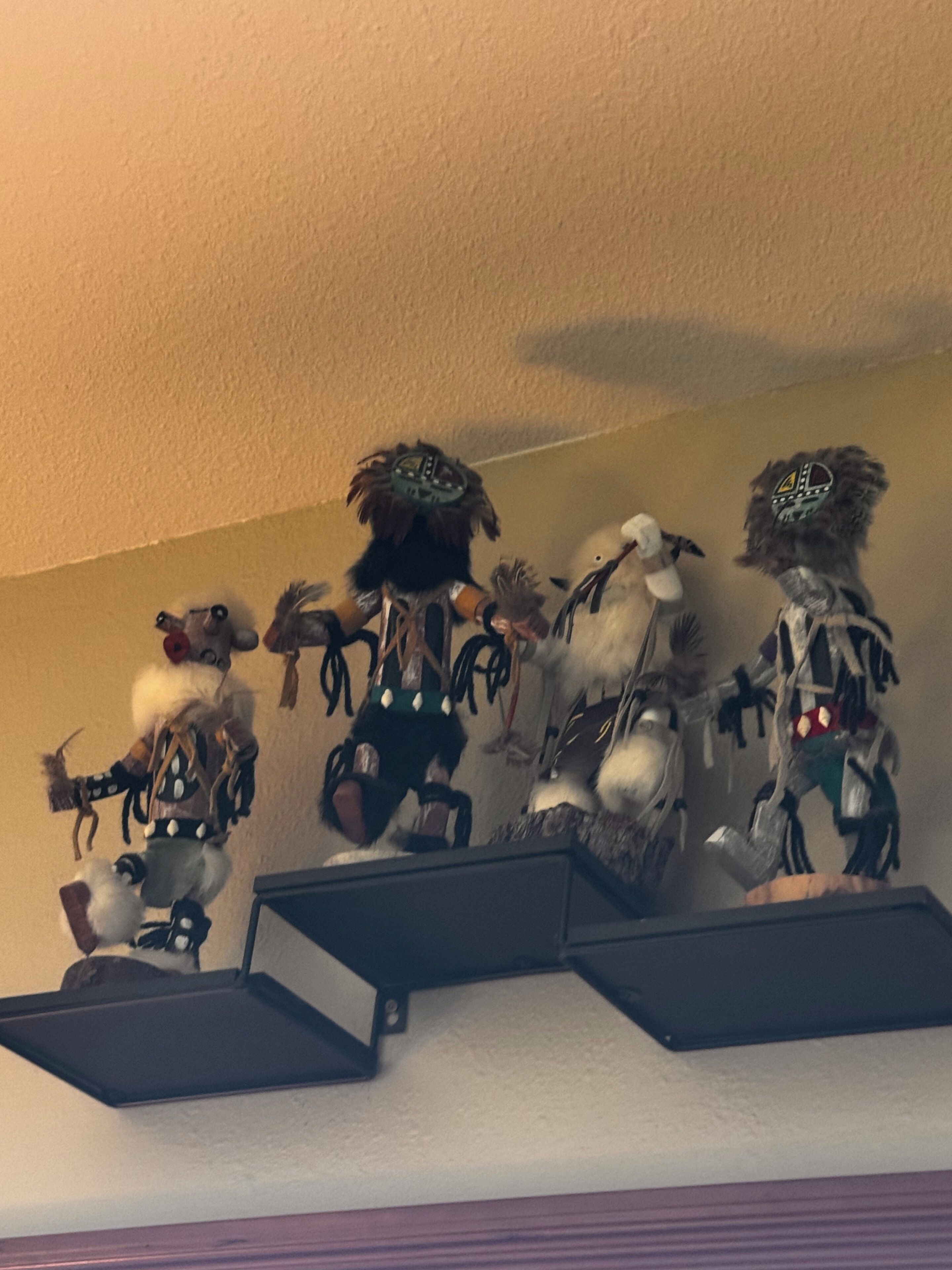 Una pared con varias figuritas exhibidas en estantes.