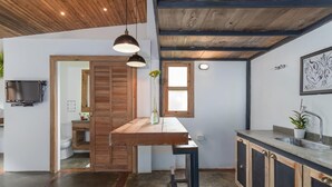 A modern kitchen with a wooden countertop, a sink, and a window. - Ipanema Hills 7 Ensuites (Rio de Janeiro)