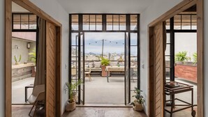 A room with a large sliding glass door leading to an outdoor balcony with a city view. - Ipanema Hills 7 Ensuites (Rio de Janeiro)