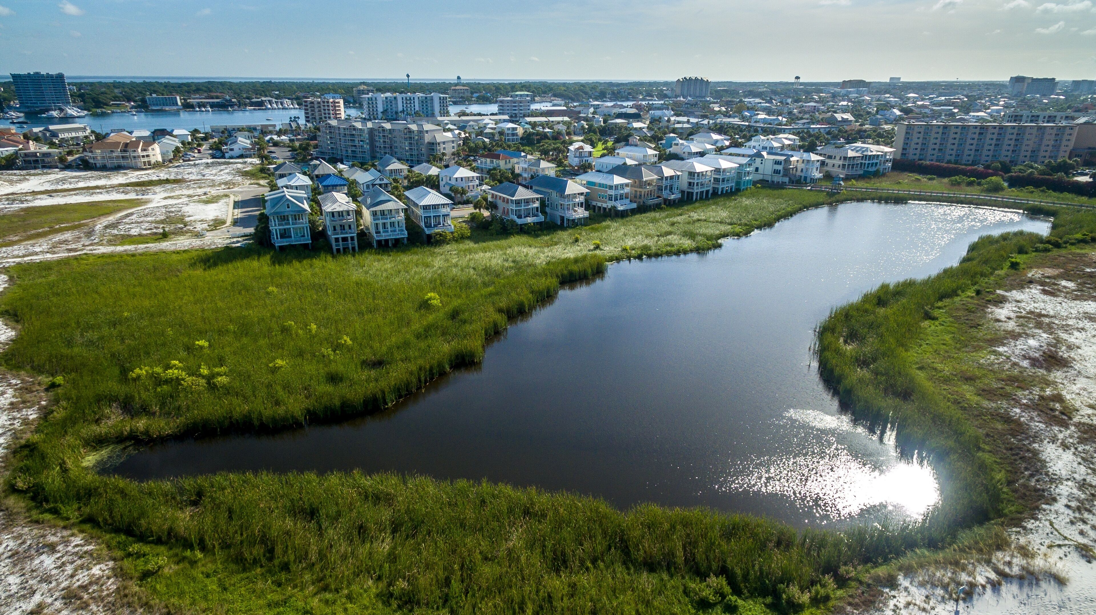 A coastal residential area with a river, houses, and a marina.