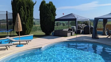 Een buitenzwembad en ligstoelen