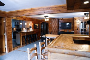 Un interior de madera con zona de bar, cocina y comedor.