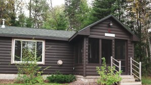 A log cabin with a small porch and a single window. - Au Sable Riverview Resort (Grayling)