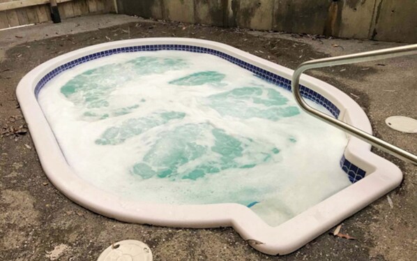 A hot tub with a blue and white tiled edge, surrounded by a concrete surface. - Perfect Location. Hot Tub and Pool. A/C (Fernie)