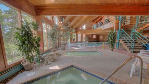 An indoor swimming pool area with multiple pools, wooden beams, and potted plants. - Cozy Wildernest Retreat w/ Mountain Views + Pool & Hot Tub (Silverthorne)