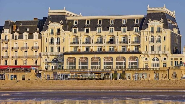 Een groot, meerhoog hotel met een klassieke Europese architectuur, herkenbaar aan de gebogen ramen en balkons langs de gevel.