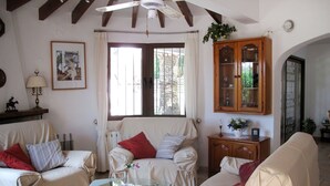 Un salon chaleureux avec deux canapés, une table basse en verre et un meuble en bois.