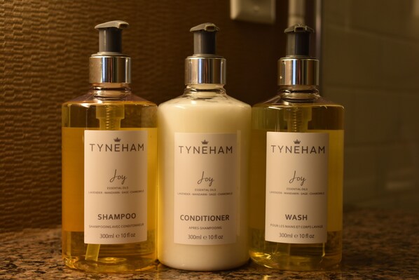 Three bottles of TYNEHAM Joy essential oils: shampoo, conditioner, and wash. - Fairways Hotel on the Mountain (Victoria)