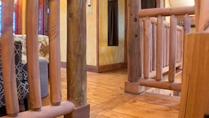 A wooden staircase leading to a room with a bed and a window.