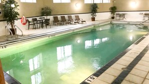 An indoor swimming pool with clear water, marked depth lines, and lounge chairs along the side. - Time for a Getaway? Pool and A/C (Fernie)