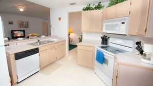 Uma cozinha moderna com armários de madeira, micro-ondas, fogão e máquina de lavar louça.