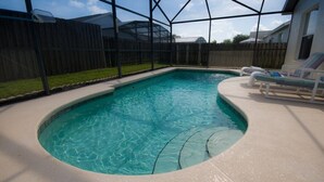 Piscina com fundo de vidro, rodeada por uma área coberta com espreguiçadeiras.