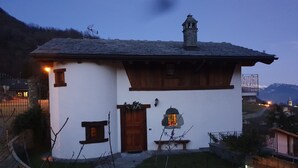 A traditional house with a stone chimney, wooden door, and a small window. - Villa la Tour Deluxe (Nus)