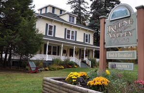 A two-story lodge with a porch and a sign indicating bed & breakfast services and a vacancy. - Keene Valley Lodge (Keene Valley)
