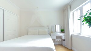Un dormitorio con cama, escritorio y silla.