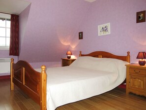 Enjoy a restful stay in this cozy room featuring a single bed, bedside tables, and a window with curtains.