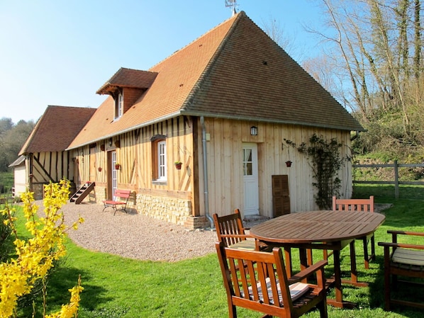 Guesthouse with a traditional wooden exterior, featuring a patio area with a table and chairs.