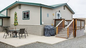 A building with a covered patio area, outdoor seating, and a barbecue grill. - Shoshone Canyon House- Great Location, Canyon Views (Cody)
