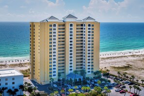 Ein Hochhaus-Hotel mit mehreren Balkonen mit Blick auf Strand und Meer.