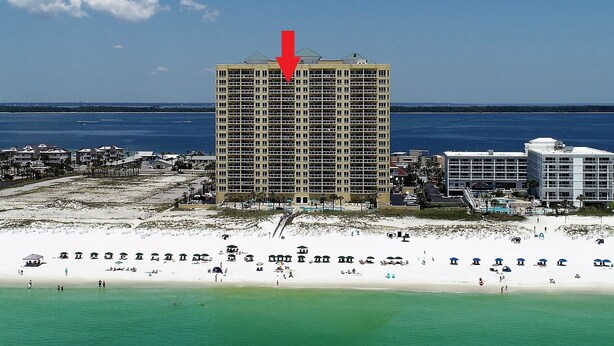 Un hôtel situé en bord de mer, doté d’un grand bâtiment, d’une plage de sable et offrant une vue dégagée sur l’océan.