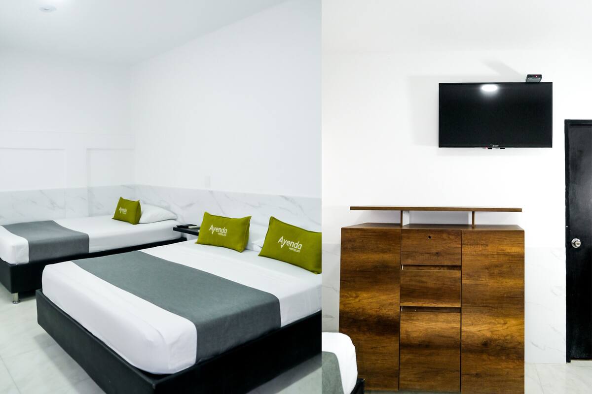 Een hotelkamer met twee bedden, een flatscreen televisie en een houten dressoir.