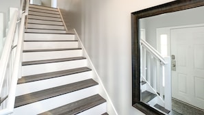 A staircase with dark wooden steps and white railings, leading to a white door. - BEAUTIFULLY  CONDO IN LEGENDS GOLF RESORT (Myrtle Beach)