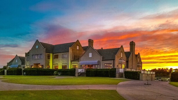 A large, multi-story building with a symmetrical facade, multiple chimneys, and a well-maintained lawn in front. - BEAUTIFULLY  CONDO IN LEGENDS GOLF RESORT (Myrtle Beach)