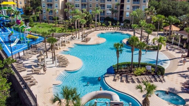 A resort with a large swimming pool, multiple water slides, and a well-maintained landscaped area. - SVV 007 - Mickeys Magical Memories 3 Bed Townhome (Kissimmee)