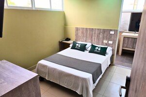 Une chambre d’hôtel comprenant un lit, une table de chevet, un bureau et une salle de bain.