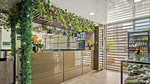 Decoração moderna com balcão de recepção, máquina de venda automática e exposição de produtos de higiene pessoal.