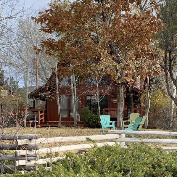 Eine rustikale Holzhütte mit Veranda, Sitzgelegenheiten im Freien und einem Schild mit dem Schriftzug 'Peter'.