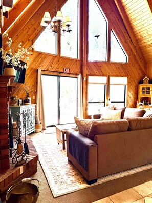Un loft amplio con techo alto, un ventanal grande y un rincón de estar acogedor.