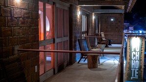 A cozy outdoor seating area with wooden benches and a sign that reads "POUCH HOTEL". - Hotel Pochote Mazunte (Santa María Tonameca)