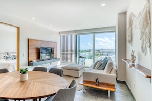 Relax in a spacious living area with a round dining table, flat-screen TV, and comfortable seating.